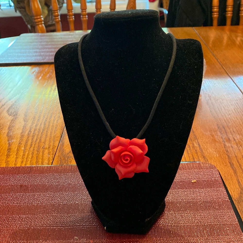 Red rose choker on velvet rope